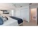 Bright bedroom featuring tiled floors, ceiling fan, and a comfortable bed with stylish blue accents and ample closet space at 3608 Eloise St, Orlando, FL 32806