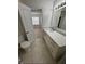 Bathroom showcasing a modern vanity with light marble countertop, open doorway and tiled floor at 3621 Atrium Dr # U-4, Orlando, FL 32822