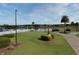 Golf course view including putting green, lake, and palm trees under a sunny sky at 3621 Atrium Dr # U-4, Orlando, FL 32822