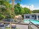 Backyard featuring an above ground pool, wooden deck, and two storage sheds surrounded by lush trees at 3788 N Econlockhatchee Trl, Orlando, FL 32817