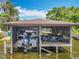 Covered boat dock featuring a boat lift, storage space, and a lounging area with seating overlooking the water at 3788 N Econlockhatchee Trl, Orlando, FL 32817