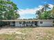 Exterior view of a well-maintained single-story home with a carport and a relaxing outdoor seating area at 3788 N Econlockhatchee Trl, Orlando, FL 32817