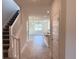 View of the neutral-toned entryway featuring a staircase and ceramic tile floors with open kitchen view at 4433 Sagefield Dr, St Cloud, FL 34773