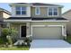Two-story home with a two-car garage, well-maintained lawn and landscaping, plus stylish neutral exterior paint at 4433 Sagefield Dr, St Cloud, FL 34773