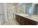 Bright bathroom featuring double sinks with white countertops and walk-in shower at 4450 Capital Blvd, St Cloud, FL 34769