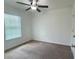 Simple bedroom with neutral carpet, a ceiling fan, and a window, offering a cozy atmosphere at 4450 Capital Blvd, St Cloud, FL 34769