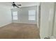 Spacious bedroom with two windows for ample light, plush carpeting, and a ceiling fan at 4450 Capital Blvd, St Cloud, FL 34769