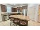 Kitchen island features granite countertop and seating, complemented by stainless steel appliances and dark wood cabinets at 4450 Capital Blvd, St Cloud, FL 34769