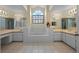 Bright bathroom boasting a large tub, neutral tile, and a large arched window at 4527 Sandhurst Dr, Orlando, FL 32817