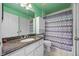 Bathroom featuring granite countertop, modern fixtures, and a shower-tub combination with patterned curtains at 4527 Sandhurst Dr, Orlando, FL 32817