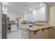 Well-lit kitchen with stainless steel appliances and a breakfast bar overlooking the living room at 4527 Sandhurst Dr, Orlando, FL 32817