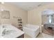 Bright bathroom with a double sink vanity, a soaking tub, and an arched doorway to the bedroom at 510 Lobelia Dr, Davenport, FL 33837