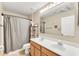 Bathroom with a double sink vanity, shower with curtain, and a large mirror at 510 Lobelia Dr, Davenport, FL 33837