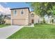 Two-story home featuring neutral siding, manicured lawn, mature trees and an attached two-car garage at 510 Lobelia Dr, Davenport, FL 33837