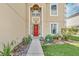 Home's front door with decorative glass, sidelights, and a manicured garden in a well-maintained lawn at 510 Lobelia Dr, Davenport, FL 33837