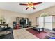 Living room with a ceiling fan and natural light illuminating a modern entertainment center and cozy seating at 510 Lobelia Dr, Davenport, FL 33837