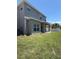 Home exterior with a covered patio and a green lawn at 5107 Ne 122Nd Blvd, Oxford, FL 34484