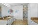 Bright bathroom with white cabinets, granite countertop and marble tiled walk-in shower at 5107 Ne 122Nd Blvd, Oxford, FL 34484