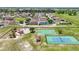 The aerial view showcases a playground, basketball court, tennis court, and open green spaces within the neighborhood at 5107 Ne 122Nd Blvd, Oxford, FL 34484