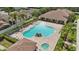Aerial view of a kidney-shaped community pool with a hot tub, surrounded by lounge chairs and lush landscaping at 5107 Ne 122Nd Blvd, Oxford, FL 34484