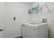 A well-lit laundry room featuring a modern washing machine and convenient shelving for storage at 5107 Ne 122Nd Blvd, Oxford, FL 34484