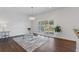 Sunlit living room with a modern chandelier, large windows with shutters, and wood floors at 5107 Ne 122Nd Blvd, Oxford, FL 34484
