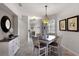 Open dining area with a rustic table and a stylish pendant light fixture at 532 Casanova Ct, Kissimmee, FL 34759