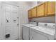 Laundry room with upper cabinets, washer, dryer, and access door with pet door at 532 Casanova Ct, Kissimmee, FL 34759