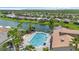 Aerial view showcases community pool, spa, and lush tropical landscaping by a lake at 532 Casanova Ct, Kissimmee, FL 34759