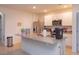 Well-lit kitchen featuring a granite-topped island, stainless-steel refrigerator, and white cabinetry at 5367 Douglas Fir Dr, St Cloud, FL 34771