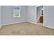 A light blue bedroom with tan carpet with a large window overlooking a lawn at 540 Monroe Cir, Davenport, FL 33896