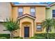 Attractive townhome with a tiled roof, neat landscaping, and an arched entryway at 540 Monroe Cir, Davenport, FL 33896
