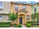 Inviting townhome with a tiled roof, well-kept lawn, and decorative shrubbery at 540 Monroe Cir, Davenport, FL 33896