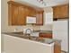 Functional kitchen with wooden cabinets, granite countertops, and white appliances at 540 Monroe Cir, Davenport, FL 33896