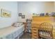 Comfortable bedroom with hardwood floors, single bed, wooden desk, and bright window, creating an efficient and inviting space at 544 Remington Oak Dr, Lake Mary, FL 32746