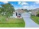 A charming single-story home featuring a well-kept lawn, mature tree, and an attached garage at 560 Viceroy Ct, Kissimmee, FL 34758