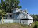 Unique two-story home with a wrap around deck and lush landscaping at 629 Helen St, Mount Dora, FL 32757