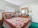 Well-lit bedroom with a wooden dresser and patterned bedding at 744 Wyman Ct # 744, Orlando, FL 32809