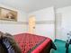 View of a bedroom with a red and black patterned bedspread and ensuite bathroom at 744 Wyman Ct # 744, Orlando, FL 32809