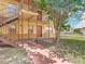 View of apartment building exterior with stairs, walkway, tree, and grass at 744 Wyman Ct # 744, Orlando, FL 32809
