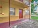 View of apartment building exterior with a red door, window, and fence at 744 Wyman Ct # 744, Orlando, FL 32809
