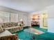 Inviting living room with floral sofas, glass coffee table, and view into dining and kitchen at 744 Wyman Ct # 744, Orlando, FL 32809