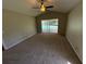 Spacious bedroom featuring neutral walls, ceiling fan, and sliding glass doors to the pool area at 7507 Sandstone Dr, Orlando, FL 32836