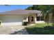 Charming single-story home with a well-manicured lawn and a two-car garage, under a clear blue sky at 7507 Sandstone Dr, Orlando, FL 32836