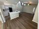 Spacious living room with wood flooring, leading to the kitchen with white cabinetry and countertops at 7507 Sandstone Dr, Orlando, FL 32836