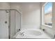 Well-lit bathroom featuring a soaking tub with a glass-enclosed shower at 7551 Bear Claw Run, Orlando, FL 32825