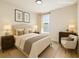 Bedroom with neutral decor, featuring a large window and comfortable furnishings at 7551 Bear Claw Run, Orlando, FL 32825