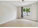 A modern bedroom with a large window, neutral walls, and wood-look floors, creating a bright, open space at 7551 Bear Claw Run, Orlando, FL 32825
