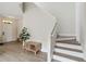 Bright entryway with coat rack, bench, wood-look floors, and stairs leading to upper level at 7551 Bear Claw Run, Orlando, FL 32825