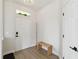 Bright entryway features wood-look flooring, coat rack, bench, and white walls with modern accents at 7551 Bear Claw Run, Orlando, FL 32825